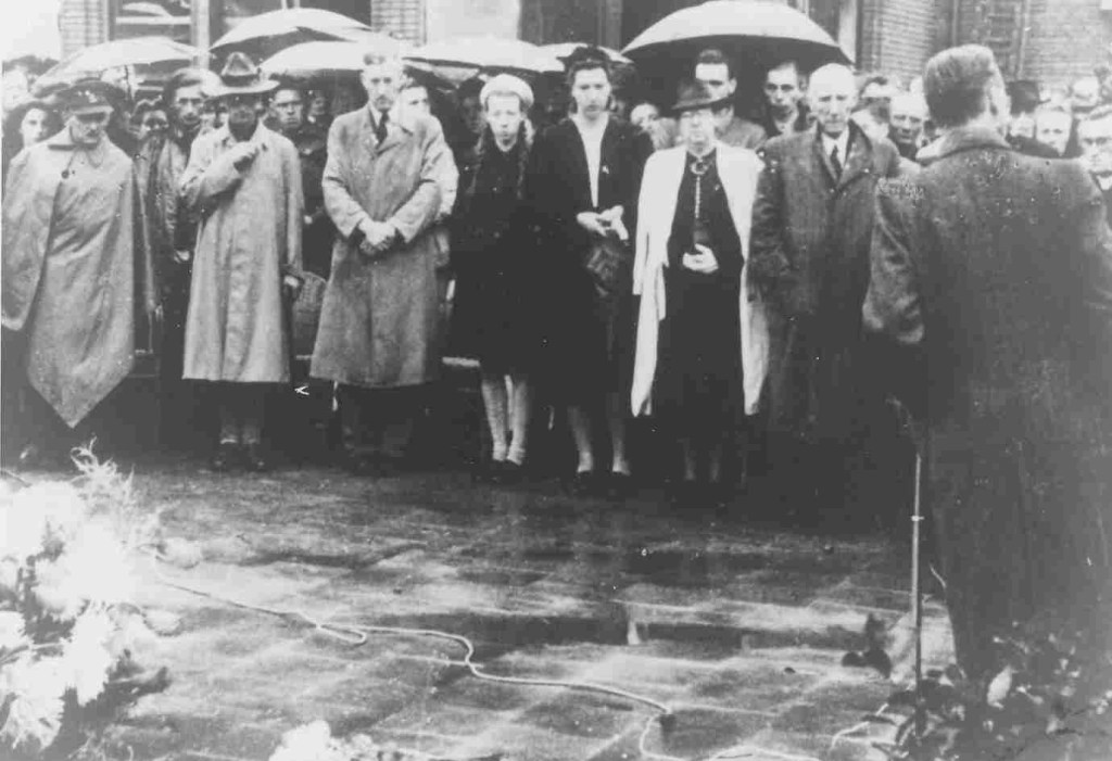 Onthulling gedenkteken voor Jan van Hoof op de Nieuwe Markt voor Terminus en Veemarkthallen. Tekst op de gedenksteen: 'Hier viel Jan van Hoof Redder der Waalbrug 19-9-1944'. Rechts op de foto Vader van Hoof, verder v.r.n.l. zijn echtgenote (in witte overjas), twee dochters en een zoon, 1945, (F71036 RAN)