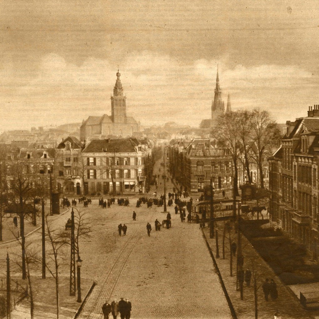 Dit panorama op de stad ziet de reiziger vanuit de richting Arnhem. De St. Stevenskerk en de St. Augustinuskerk torenen boven de huizen uit. Links de Nieuwe Markt, in het midden de Lange Hezelstraat en rechts de Parkweg; de tram draait de Kronenburgersingel op richting station, 2/1923 (Uit Katholiek Illustratie via F9308 RAN)