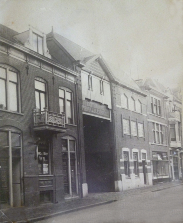 Straatbeeld, tweede helft jaren twintig, met de inrijpoort van het nieuwe, door architect M.E. Veugelers ontworpen bedrijfscomplex van Houthandel Firma J.H. Emmerik, geopend op 26 september 1927, Ziekerstraat 99, 1927-1928 (F9671 RAN)