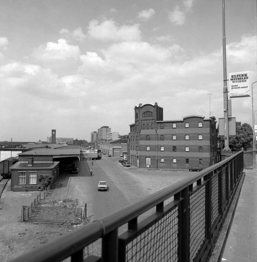 Blik vanaf de Graafsebrug op de loodsen van Van Gend & Loos met rechts het voormalige pand van de TURMAC (de Turkish Macedonian Tobacco Company), 1980 (Ber van Haren via ZN36125 - A RAN CC0 Auteursrechthouder: Gemeente Nijmegen)
