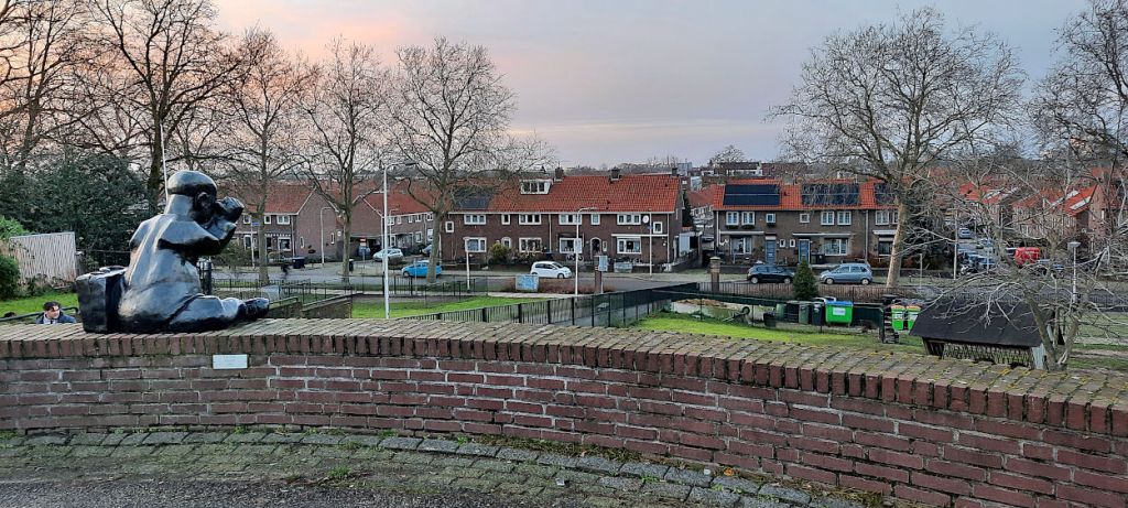 Mannetje met verrekijker en aktetas kijkt uit over het lager gelegen deel van de Wolfskuil (januari 2021)