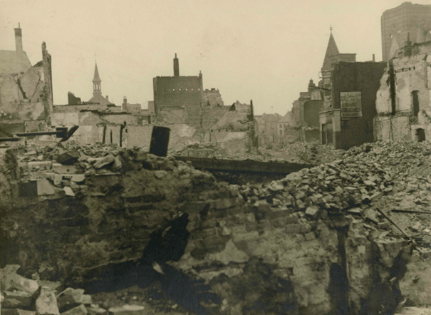 Bijschrift RAN: De door het bombardement van 22 februari 1944 weggevaagde Houtstraat; links de kapel van het Carmelklooster en rechts de wandreclame van W. Münchau toneelkapper die zijn zaak dreef op Houtstraat 10, hoek Jodengas, 22/2/1944-3/1944 (F75427 RAN)