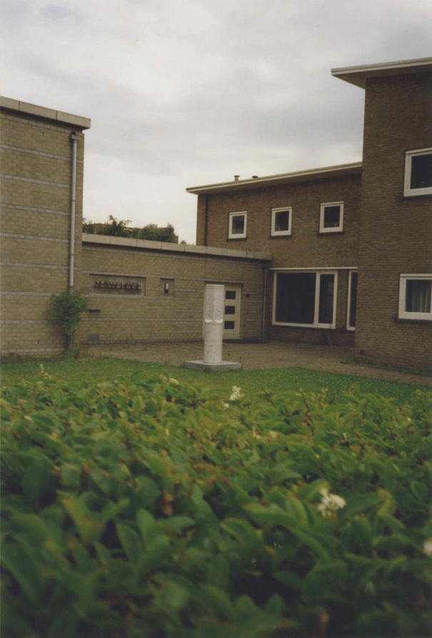 De uitbouw van de vleugel, rechts de school, links de gymzaal. Op de voorgrond 'Zuil', kunstwerk uit 1988 van Peter van de Locht (Rees Dld, 1946) voor de Nutsschool, 1988 (Martine Ridderbos via F24615 RAN CC-BY_SA)