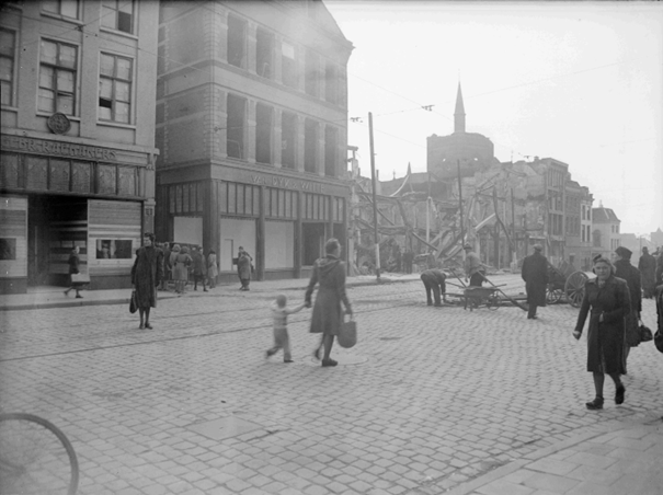 Het door het bombardement van 22 februari 1944 totaal verwoeste pand van Vroom en Dreesmann (rechts) met op de achtergrond de restanten van de St. Augustinuskerk; links de schoenenzaak van de gebroeders Raemakers en de herenmodezaak van Van Dijk en Witte, 22/2/1944-30/6/1944 (GN11080 RAN)