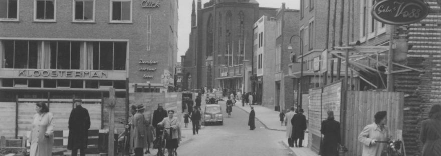 Boekhandel Kloosterman in de Broerstraat: gezien vanuit de Molenstraat, midden rechts de Pauwelstraat; op de achtergrond het restant van de door oorlogsverwoestingen gehavende St. Dominicuskerk, 1950 (Commissariaat van Politie afd Fotografie via F15109 CC0) architect Lelieveldt