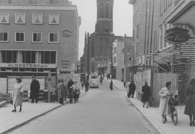 Boekhandel Kloosterman in de Broerstraat: gezien vanuit de Molenstraat, midden rechts de Pauwelstraat; op de achtergrond het restant van de door oorlogsverwoestingen gehavende St. Dominicuskerk, 1950 (Commissariaat van Politie afd Fotografie via F15109 CC0) architect Lelieveldt