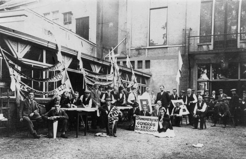 Leden van de R.K. Werkliedenvereeniging (RKWV) St. Stephanus, bijeengekomen om het Demonstratief Congres op 17 juni 1927 voor te bereiden. De foto is genomen aan de achterkant van het R.K. Vereenigingsgebouw Unitas, de vroegere sociëteit Burgerlust.