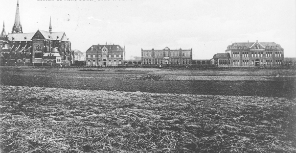 Het Pensionaat Instituut Johanna de Lestonnac (eerste gebouw rechts van de kerk), de Lagere School en het Klooster van het "Convent de Notre Dame" (Zustercongregatie van de Dochters van O.L. Vrouw) (patrones Johanna de Lestonnac). Links de Groenestraatskerk (H. Antonius van Padua / St. Annakerk). Voor de rest nog een vrij lege omgeving, 1915-1925 (F16134 RAN) Dobbelmannweg 1 3 en 5