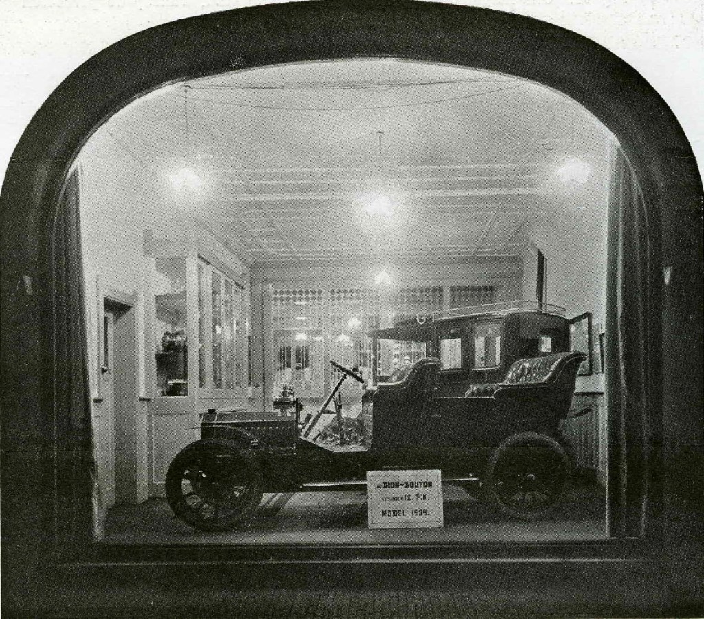 Het fraaie effect van een gloeilampverlichting in een helder wit geschilderde etalageruimte van de garage L.A. Moll (importeur van de Dion Bouton) bij avond. Reproductie uit: Gebruikt Electriciteit! Reclame uitgave der Gemeente-Electriciteitswerken te Nijmegen, eerste serie no. 2 'Onze Winkels', Nijmegen 1910; het pand is ontworpen in Jugendstil door Oscar Leeuw in 1909 in opdracht van L.A. Moll, 1910 (F47567 RAN)