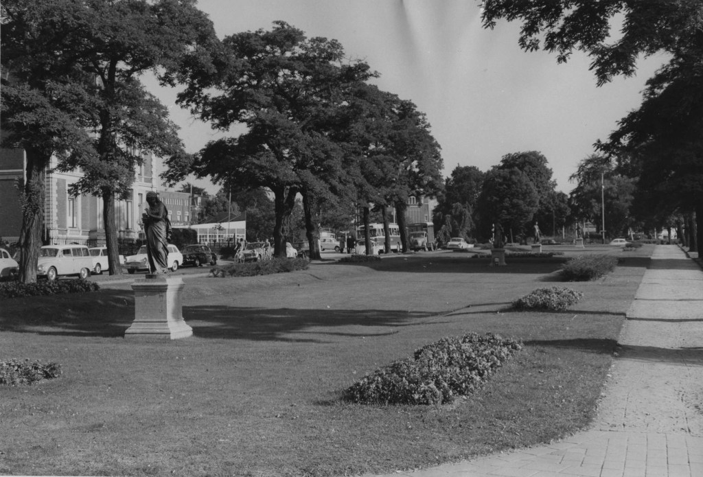 Beeld van de singel, eerste helft jaren zestig, gezien in de richting van het Keizer Karelplein, met de gietijzeren beelden van de 'De vier jaargetijden', vervaardigd door de Franse beeldhouwer Mathurin Moreau in 1889. Van voor naar achter achtereenvolgens Vesta (Winter), Pomona (Herfst), Ceres (Zomer) en Flora (Lente), 1964 (Gemeentepolitie Nijmegen via F88463 RAN CC0)