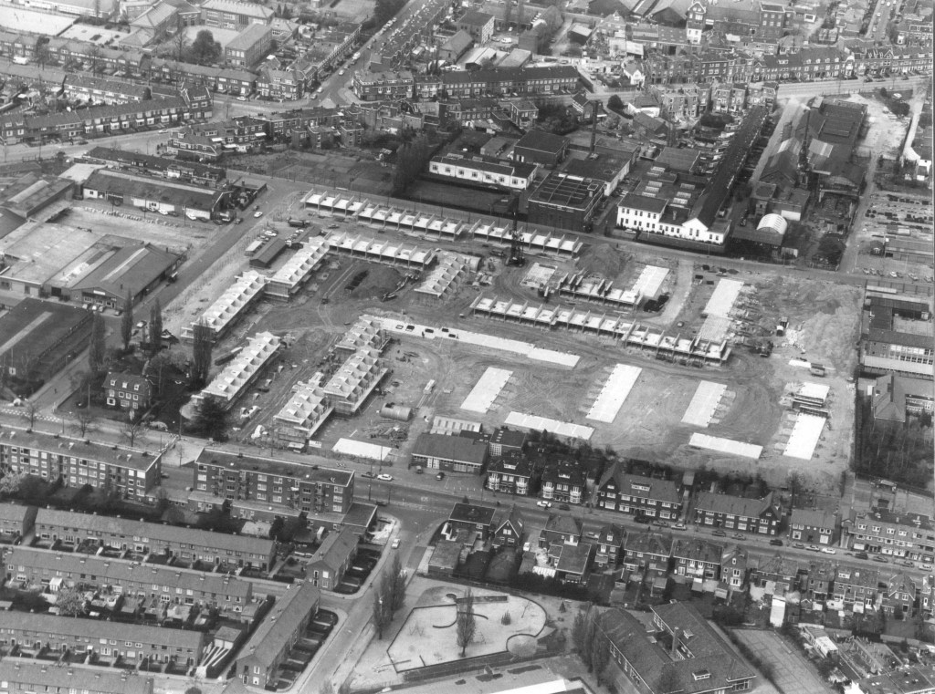 Boven de nieuwbouw van de Zwaluwstraat Brocades en de ijzergieterij: Luchtfoto van het voormalig terrein van de Nijmeegse Veiling (afgebroken in 1976) ; Hier worden huizen gebouwd aan de Zwaluwstraat ; Linksonder op dit terrein , op de hoek met de Koekoekstraat, staat de (thans nog bestaande) voormalige directeurswoning van de Veiling ; onderin loopt v.l.n.r. de Marialaan ; onderin in het midden de Pluvierstraat ; bovenin loopt v.l.n.r. de Voorstadslaan, met daaronder v.l.n.r. de Sperwerstraat ; rechtsboven (tussen Voorstadslaan en Sperwerstraat) liggen de bedrijfscomplexen van de pleisterfabriek Brocades (later worden hier appartementencomplexen gebouwd aan de Graspieperhof) en de Nijmeegse IJzergieterij (na afbraak zouden hier later woningen gebouwd worden aan de Boomvalkstraat , de Scholeksterstraat en de Torenuilstraat), 1980 (J.F.M. Trum via F21046 RAN CCBYSA)