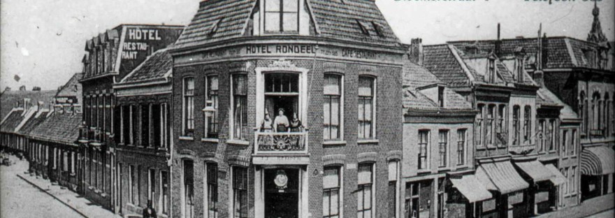 Hotel-Café-Restaurant 't Rondeel van A.J.J van Kempen met twee koetsen en mensen op het balkon en in de deuropening; links oude huisjes aan de Eerste Walstraat, nu een Grieks restaurant, 1895-1900 (dr. Jan Brinkhoff via D41 RAN CC0)