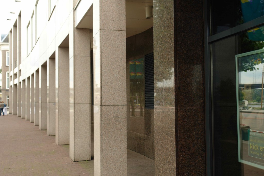 De pilaren aan de voorgevel van het Holland Casino zijn bedekt met platen van rose graniet en bruine syeniet, 24/6/2007 (Jeroen van Lith via F9148 RAN CCBYSA)