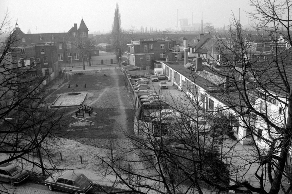 Kijkend vanaf het dak van Vissers Meubelen aan de Eerste Oude Heselaan in de richting van het speeltuintje aan de Kauwstraat; Rechts het terrein en pand van Autospuiterij Wijnhoven B.V. aan de Eerste Oude Heselaan 274 t/m 270, 1978-1980 (Gemeente Nijmegen via KN11415-42 RAN CC0)