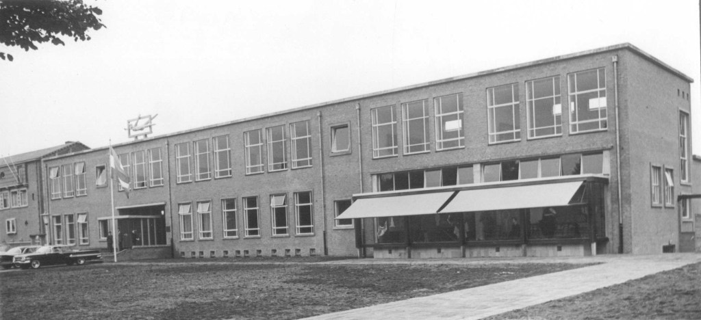 Detailhandelschool ; boven de ingang het beeld "Mercurius ', gemaakt in 1962 door Ed van Teeseling, 28/9/1962 (Fotopersbureau Gelderland via F20242 RAN CCBYSA Auteursrechthouder: J.F.M. Trum)