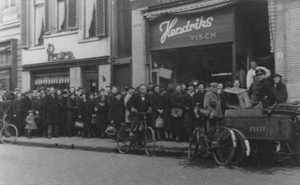 Links Pelser; Een rij wachtende klanten bij de Viswinkel van Hendriks, 1942 (F65361 RAN)