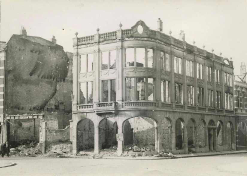 Het tijdens de bevrijding verwoeste winkelpand van Hofbontwerkerij Theo A. Hendriksen. Alleen de gevel van dit grote hoekpand staat nog overeind. Links de Bisschop Hamerstraat, 9/1944-12/1944 (F68523 RAN)