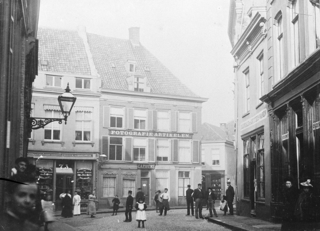Het gezicht in de richting van de Priemstraat, en naar de panden van C.A.P. Ivens, fotograaf en H.A. Tesser, drogist, links de Lange Brouwerstraat, 1895 (GN2708 - A RAN)
