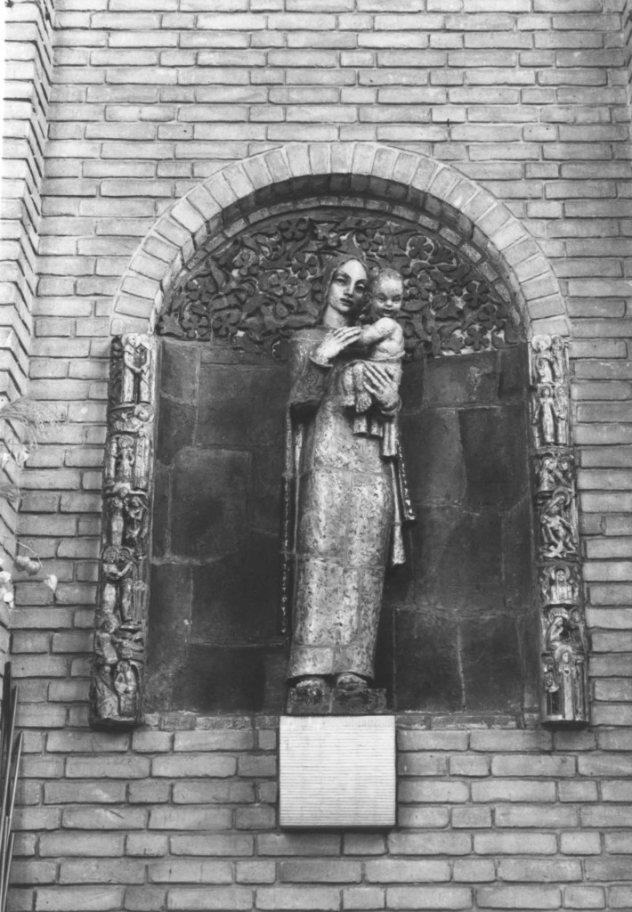 Maria met Kind geflankeerd door 2 levensbomen met scenes uit het leven van Maria door de beeldhouwer Jac Maris, eind dertiger jaren, voor de Mariakapel van de Christus Koningkerk. Na afbraak van de kerk in 1993 kregen de 2 stijlen een plaats in het Marishuis te Heumen. Maria met kind werd herplaatst in de Dominicuskerk aan de Prof. Molkenboerstraat, 1986 (Anton van Roekel via F16262 RAN CCBYSA)