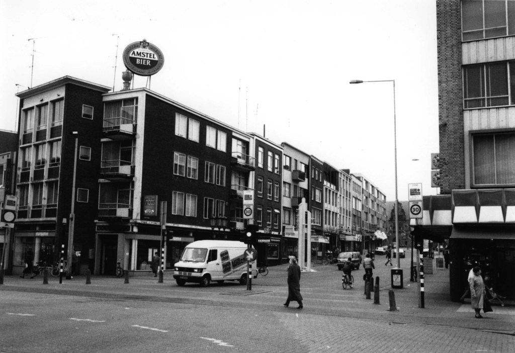 In 1992 stond het carillon aan de overkant van de straat; Augustijnenstraat gezien vanaf Plein 1944, links de Houtstraat, 1992 (Toon Opsteegh via F6118 RAN CCBYSA)