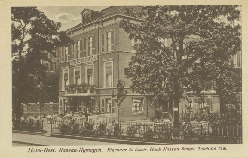 Hotel Restaurant Nassau opende op 22 april 1922 haar deuren in het statige pand dat werd bewoond door de steenfabrikant Löben Sels; uitbater was de heer J.N.E. Esser; links is nog een glimp van het Kolpinghuis zichtbaar. De foto is genomen vanaf de Nassausingel, 1922-1930 (Uitg. P.M. Eenennaam via F30655 RAN)