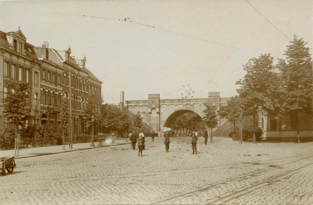 Straatbeeld, met het spoorwegviaduct (Nieuwe Hezelpoort), gezien vanaf de hoek met de Nieuwe Markt, 1915-1920 (Uitg. La Rivière & Voorhoeve via F88938 RAN)
