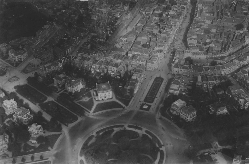 Luchtfoto van het Keizer Karelplein en omgeving ; linksonder (tussen Stationsweg en Nassausingel) de villa van het gezin van de Baksteenfabrikant A.P.A. Terwindt (Keizer Karelplein 10) ; daarboven de villa's aan de Nassausingel 3 en Nassausingel 5 (het woonhuis van J.G. Jurgens, directeur van de Maas en Waalsche Bank). Op de plek van deze drie villa's is in 1960 de Stadsschouwburg gebouwd. Aan de overzijde de (thans nog steeds bestaande) villa's aan de Nassausingel 2 en 4 ; rechts daarvan (op de hoek met de Bisschop Hamerstraat) de witte villa van de margarinefabrikant Arnoldus Jurgens (Keizer Karelplein 11, het latere Universiteitsgebouw waar tegenwoordig de ABN/AMRObank staat) ; rechts van de Bisschop Hamerstraat de villa's Keizer Karelplein 1 en 2 (hier werd later de Boerenleenbank / Rabobank gebouwd) ; linksboven het Kolpinghuis (de Gezellenvereniging) tussen de Van Berchenstraat en de Smetiusstraat ; ervoor wordt de Marie-Adolffontein gebouwd., 1925-1926 (F58044 RAN)