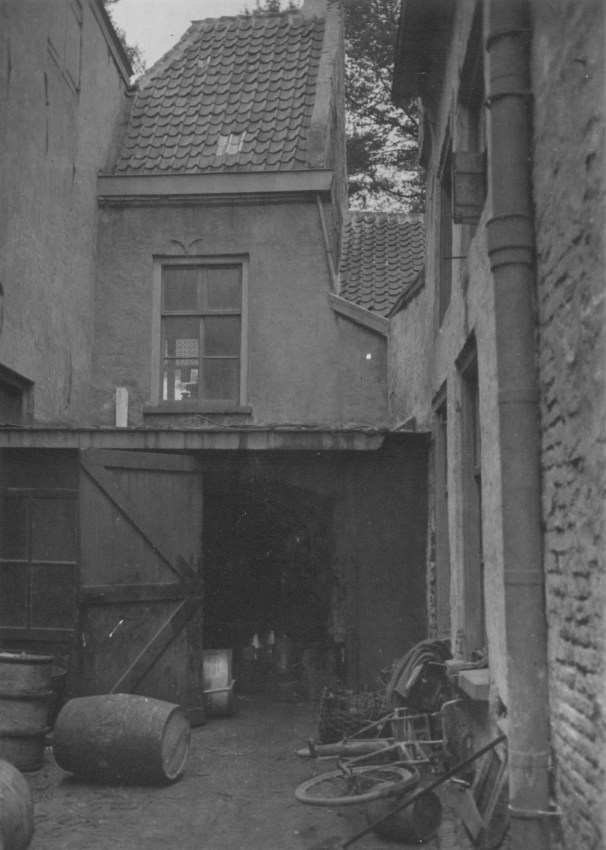Het binnenplaatsje van de Oliehandel Van Pelt , met de verborgen St. Antonispoort, Lage Markt, 1960 (Fotopersbureau Gelderland via F19044 RAN CCBYSA tevens Auteursrechthouder)