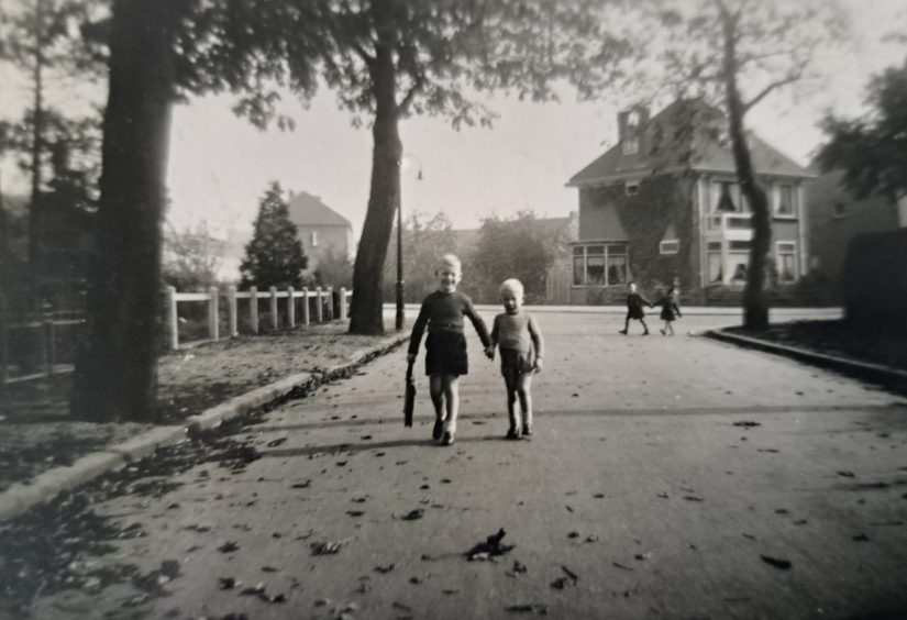 Een wandeling op de Prinsenlaan, die rechts afbuigt. Op de hoek is Prinsenlaan 18 (huidig nummer) te zien en nog een klein stukje Prinsenlaan 12 rechts daarvan. De weg links is de Patrijsstraat: daar is 1 van de nieuwbouwwoningen te zien (en vaag links daarvan een aantal andere nieuwbouwwoningen), 1955/1956; Foto beschikbaar gesteld door J. Krijff, copyright J. Krijff