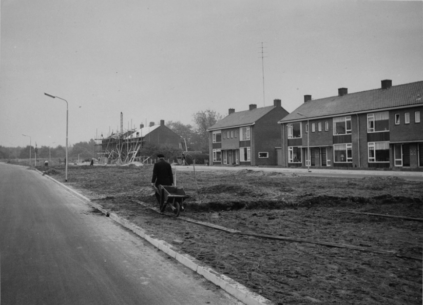 Straatbeeld, beginjaren zestig, gezien in de richting van de Buijs Ballotstraat, met de pas gebouwde en nog in aanbouw zijnde woningen van architect Th. H. B. Arens en de aanleg van het plantsoen tussen de Edisonstraat (rechts) en Archimedesstraat (links). Op de open plek tussen de woningen wordt in 1969 een dubbele woonhuis met garages gerealiseerd, 1960 (Gemeentepolitie Nijmegen via F88472 RAN CC0)