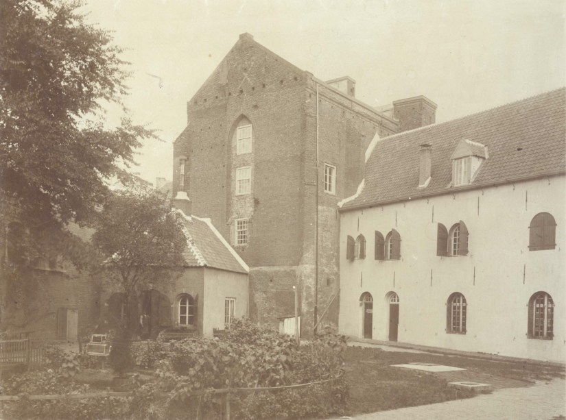 Het gezicht vanuit het zuid-westen, op de westelijke gevel van de Mariënburgkapel, en het later verdwenen zuidelijk gedeelte van het Gemeente Archief, voor de verbouwing in 1910; de originele foto in chamois, 1885 (F30148 RAN)