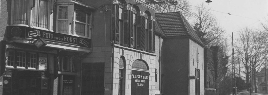 Tweede zaak van Fotohandel van der Horst, Jorisstraat 13, 1932 (Fotopersbureau Gelderland via F14667 RAN CCBYSA Auteursrechthouder: J.F.M. Trum) Een rij winkels tussen het Kelfkensbos en de Walmuur. Te zien zijn de metaalhandel A. Frank & Zonen en fotozaak Van der Horst. Rechts is nog een deel van het Poortwachterhuys te zien.
