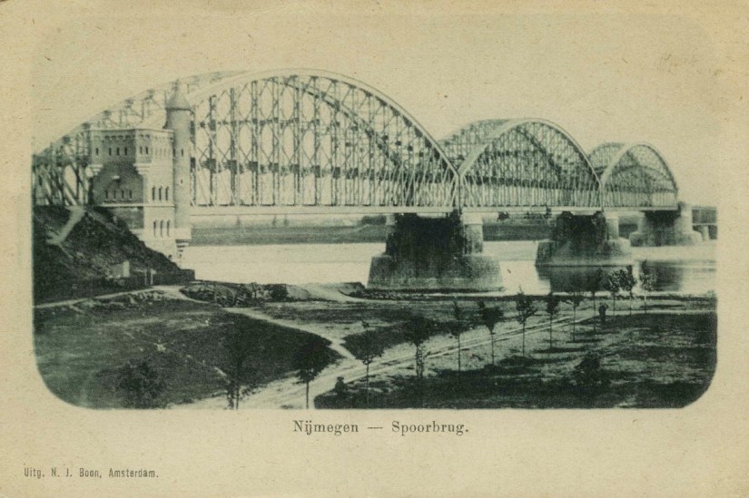 De drie boogoverspanningen van de oude (vakwerk)spoorbrug over de Waal uit 1879 met (links) het zuidelijk landhoofd van architect P.J.H. (Pierre) Cuypers, 1902-1906 (F91347 RAN)