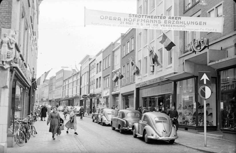 Gezicht op de oostzijde van de Broerstraat, met o.a. de winkelpanden van (v.r.n.l.) Schoenhandel Van Haren, Juwelier Van Hout Ververgaard, Zaadhandel Lahey-Fliervoet, Het Zuivelhuis, kledingzaak Het Jaegerhuis, Stoffenhandel Hommen en Co, Juwelier Jac van Baal , Herenmodezaak J.S. Meuwsen en Warenhuis Firma A.A. van der Borg, 1955 (GN3872 RAN)