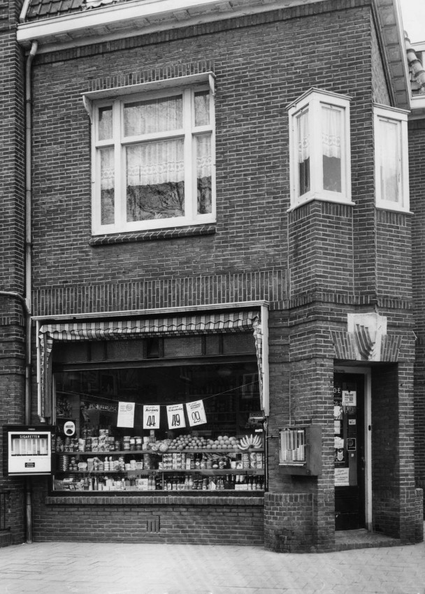 De kruidenierswinkel van A.F.C. Ros op de hoek Javastraat en Celebesstraat. Anno 2026 is het pand een woonhuis met voortuin, Javastraat 37, 7/1962 (Nico Grijpink via F92054 RAN CCBYSA)